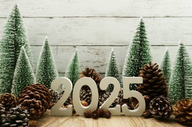 Yeni yılınız kutlu olsun. Noel ağacı ve ahşap arka planda çam kozalakları.