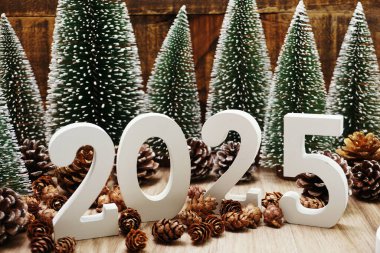 Yeni yılınız kutlu olsun. Ahşap arka planda Noel ağacı ve çam kozalağı süslemesi var.