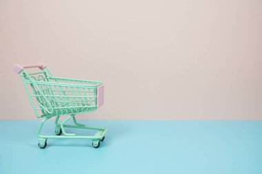 Mini Trolley alışveriş arabası pembe ve mavi arka planda metin için yer var.