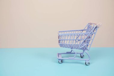 Mini Trolley alışveriş arabası pembe ve mavi arka planda metin için yer var.