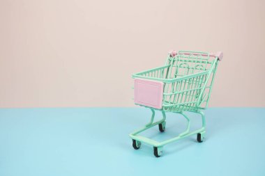 Mini Trolley alışveriş arabası pembe ve mavi arka planda metin için yer var.