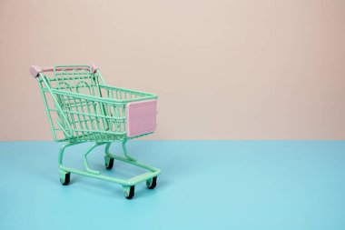 Mini Trolley alışveriş arabası pembe ve mavi arka planda metin için yer var.