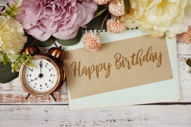 Kağıt karttaki doğum günü mesajınız kutlu olsun. Çiçek kenarlı çerçeve tahta arka planda.