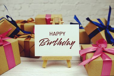 Kağıt üzerinde Mutlu Yıllar metni ve tahta arka planda hediye kutusu