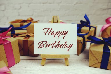 Kağıt üzerinde Mutlu Yıllar metni ve tahta arka planda hediye kutusu