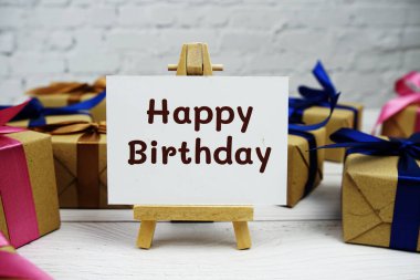 Kağıt üzerinde Mutlu Yıllar metni ve tahta arka planda hediye kutusu