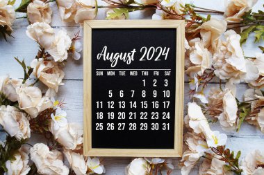 Ahşap arka planda çiçek buketi desenli aylık Ağustos 2024 takvimi