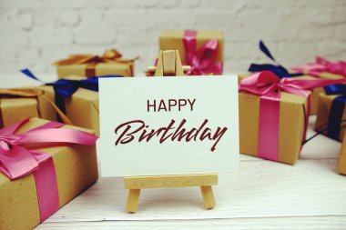 Kağıt üzerinde Mutlu Yıllar metni ve tahta arka planda hediye kutusu