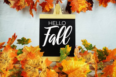 Merhaba. Ahşap zemin üzerinde akçaağaç yaprakları olan güz mesajı