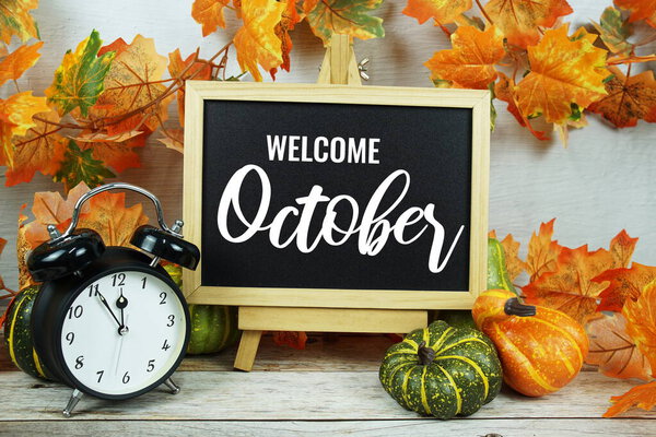 Добро пожаловать Октябрь текстовое сообщение с осенью кленовые листья украшения на деревянном фоне