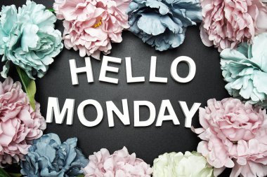 Merhaba Pazartesi alfabesi harfi. Siyah arka planda çiçek süslemesi var.