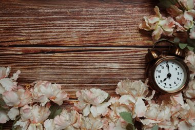 Alarm saati ve ahşap arkaplanda çiçek süslemesi olan arkaplan kopyası