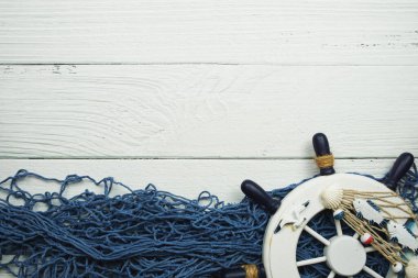 Ahşap zemin üzerinde yer kopyası olan Denizcilik Tekerleği ve Mavi Balıkçılık Ağı