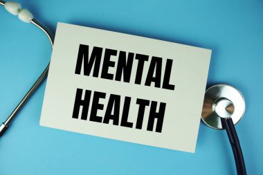 Kağıt üzerinde mavi arkaplanda steteskop üst görünümü olan Ruh Sağlığı metni