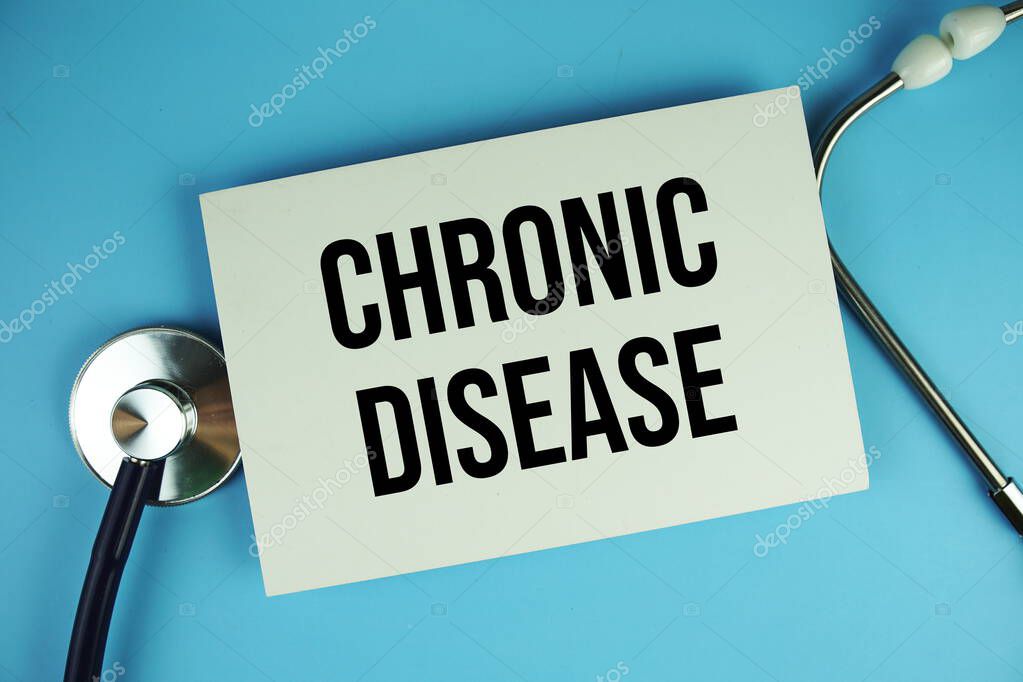 Chronic Disease text on paper card with stethoscope top view on blue background