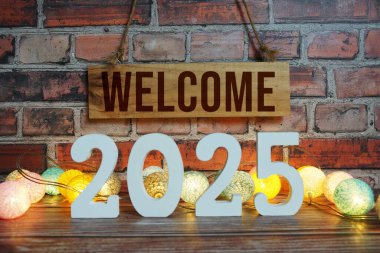 Hoş geldiniz 2025 Yeni yılınız kutlu olsun LED pamuk topları ile ahşap arka planda