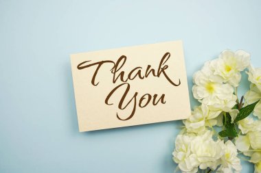 Mavi arkaplanda çiçek süslemeli teşekkür mesajı