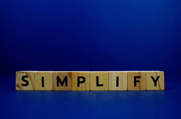 Simplify with wooden blocks alphabet letters and Magnifying glass on blue background