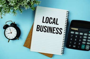 Yerel İş metni, hesap makinesi ve alarm saati ile kağıt üzerine yazılmış mavi arkaplan