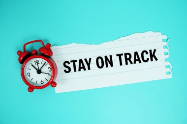 Alarm saati üst görünümü ile mavi arkaplanda yırtılmış kağıt üzerine yazılmış metni Planlamak İçin Zaman Al