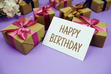 Mor zemin üzerinde hediye kutusu olan mutlu yıllar kartı.