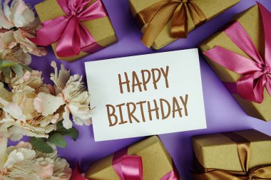 Mor zemin üzerinde hediye kutusu olan mutlu yıllar kartı.