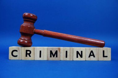 Ahşap blok alfabe harfleri ve mavi arka planda Gavel olan suç alfabesi harfleri.