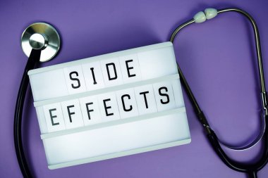 LED Işık Kutusu 'ndaki yan efekt metni ve mor arka plandaki steteskop, sağlık konsepti