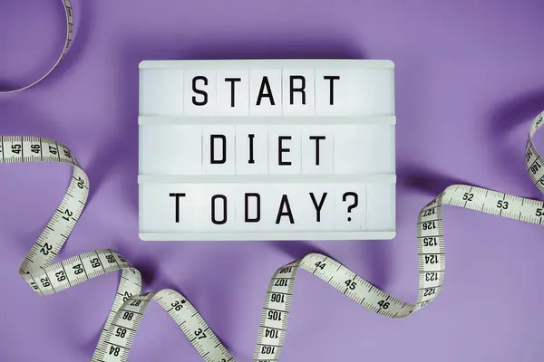 stock image Start diet today? letterboard text on LED Lightbox and Measuring tape on purple background, Healthcare concept