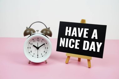 Kağıt üzerinde size iyi günler dilerim. Pembe arka planda çalar saat var.