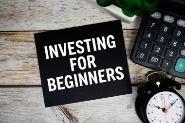 Yeni başlayanlar için tahtadan arka plan, iş konsepti üzerinde alarm saati ve hesap makinesi ile yatırım