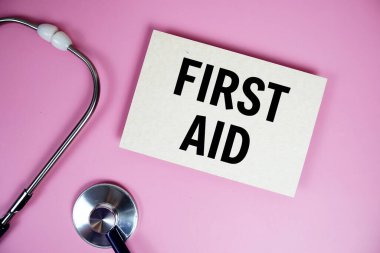 Pembe arka planda steteskoplu ilk AID metni, sağlıklı ve sağlıklı olma kavramı
