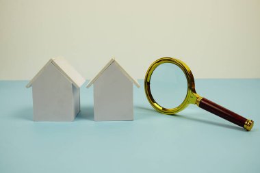 Beyaz Model Evi ve mavi arkaplanda boşluk kopyası olan büyüteç