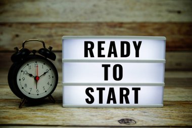 LED ışık kutusunda, ahşap zemin üzerinde alarmlı saat ile metne başlamaya hazır