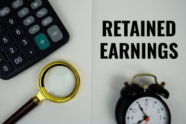 Hesap makinesi, alarm saati ve büyüteçle not sayfasına yazılan geri alınan Gelir metni