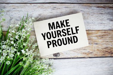 Kağıt kartın üzerinde, çiçek buketi ile ahşap arka planda kendi kendinizin oluşturduğu metin