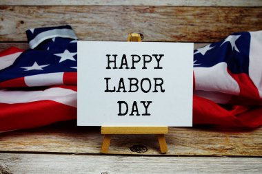 Ahşap zemin üzerinde ABD bayrağıyla Mutlu İşçi Bayramı mesajı