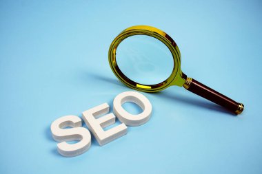 Mavi arkaplanda büyüteç görünümlü SEO sözcüğü