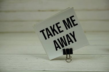 Beni uzaklara götür. Tahta arka planda yapışkan bir nota mesaj yaz.