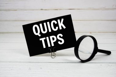 Tahta arka planda büyüteç bulunan kağıt kartla hızlı ipuçları gönderir