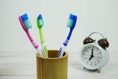 Çalar saat diş fırçası ahşap arka planda diş hijyeni kavramı