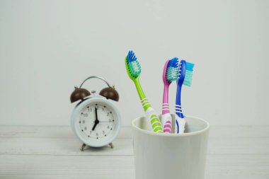 Çalar saat diş fırçası ahşap arka planda diş hijyeni kavramı