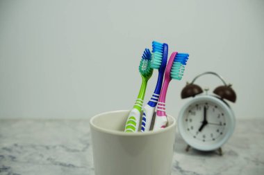 Çalar saat diş fırçası mermer arka planda diş hijyeni kavramı