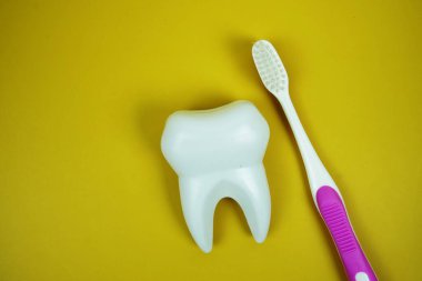 Diş fırçası ve diş hijyeni konsepti sarı arka planda üst görünüm