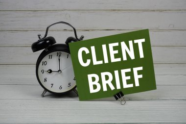 Tahta zemin üzerinde alarm clcok ile kağıt kart üzerinde istemci Brief kısa kısa mesaj