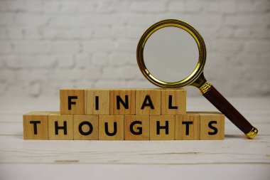 Tahta bloklar, alfabe harfleri ve ahşap zemin üzerinde büyüteç içeren son düşünceler