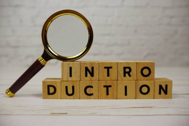 Tahta bloklar, alfabe harfleri ve tahta arka planda büyüteçle giriş.