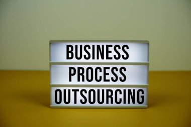 LED ışık kutusu üzerinde sarı zemin üzerinde alarm saati olan İş Süreci Dış Kaynak metni