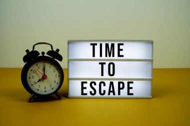 Sarı zemin üzerinde alarm saati olan LED ışık kutusundaki metinden kaçış zamanı