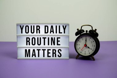 Günlük rutininiz Mor zemin üzerinde alarm saati olan ışık kutusundaki metinler